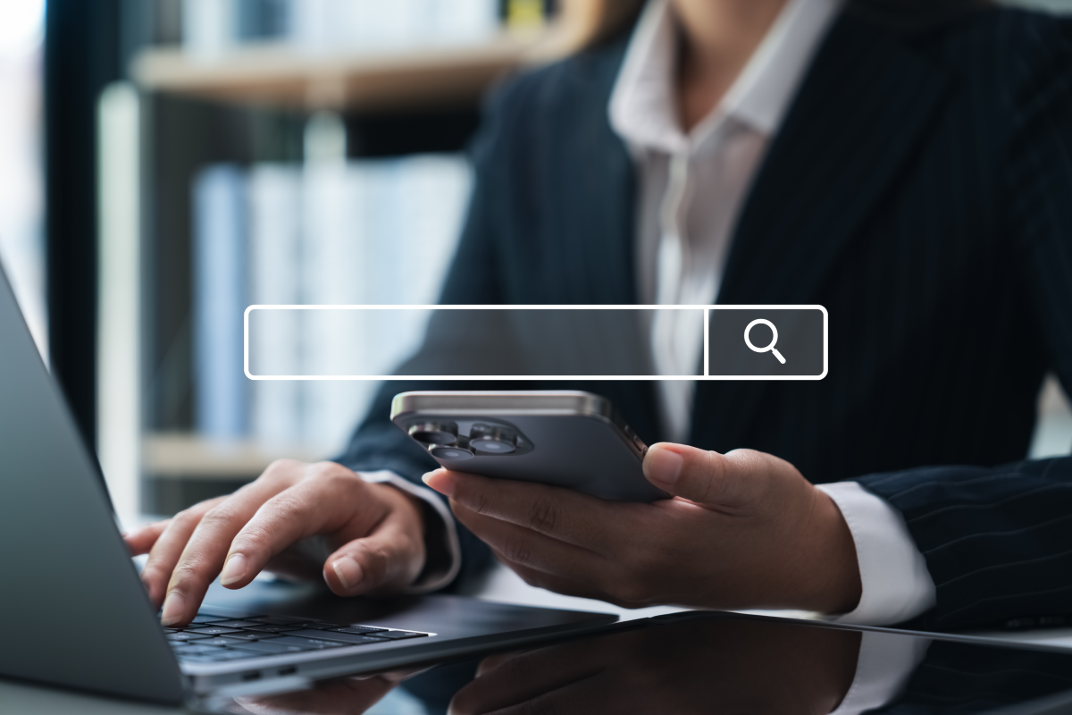 Osoba v business oblečení používající vyhledávání na telefonu