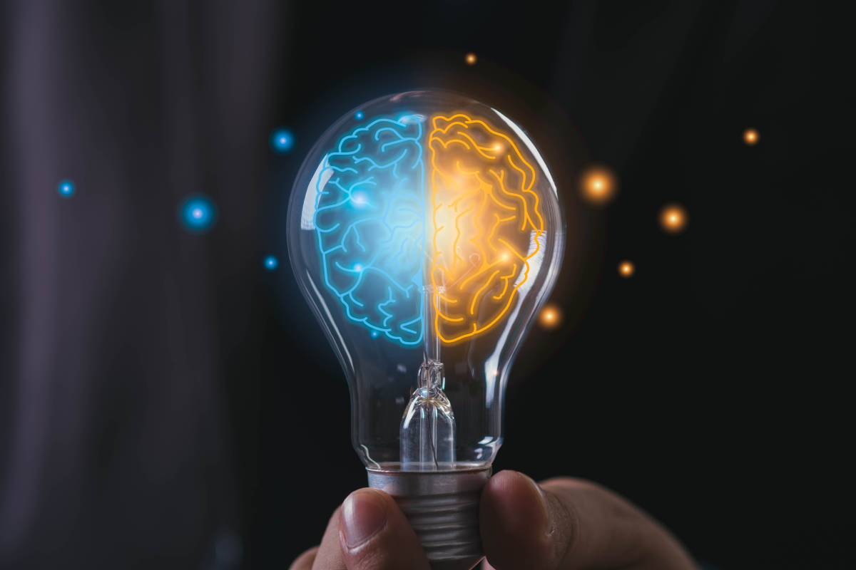 Emisferi cerebrali sinistro e destro evidenziati in colori all'interno di una lampadina